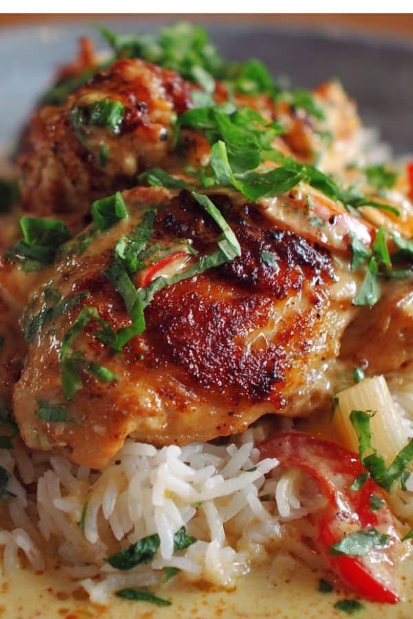 Skillet of Creamy Smothered Chicken and Rice Recipe thighs in rich gravy over rice