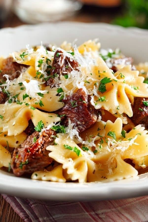 “Garlic Butter Bowtie Pasta with Beef Perfection served in a skillet with creamy garlic butter sauce and fresh parsley on top