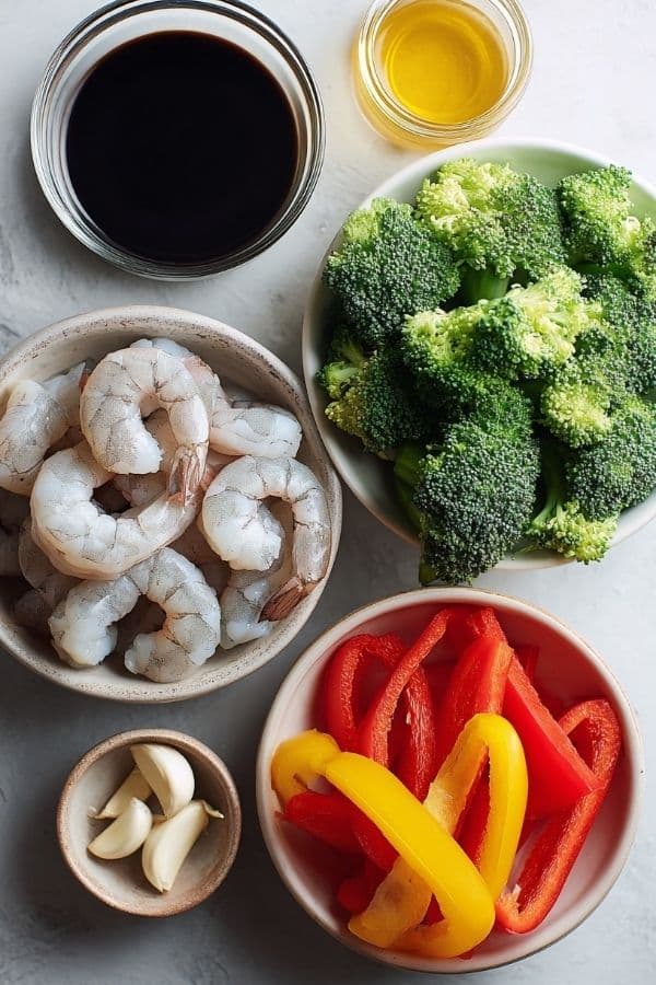 Ingredients for High-Protein Honey Garlic Shrimp including shrimp, garlic, honey, soy sauce, and vegetables.
